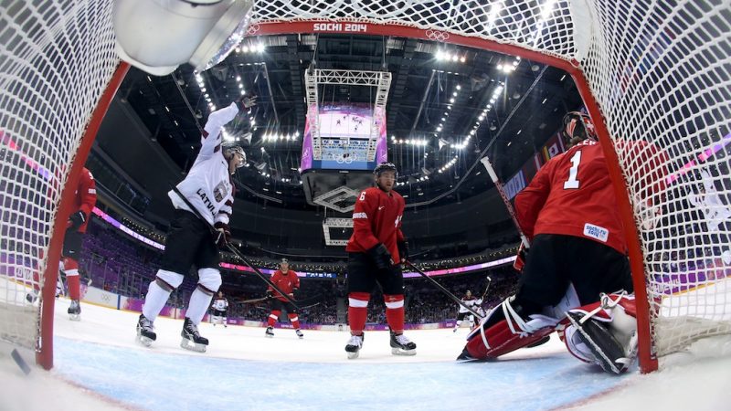 SOCHI, RUSSIA - FEBRUARY 18:  Jonas Hiller #1 of Switzerland gives up a goal in the first period to Lauris Darzins #10 of Latvia during the Men's Ice Hockey Qualification Playoff game on day eleven of the Sochi 2014 Winter Olympics at Bolshoy Ice Dome on February 18, 2014 in Sochi, Russia.  (Photo by Bruce Bennett/Getty Images)